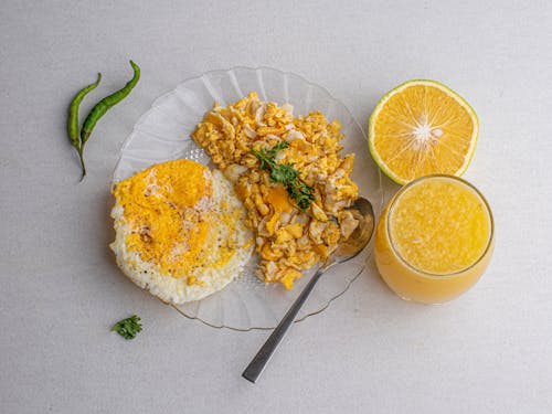 Free Orange Juice Beside a Plate Full of Food Stock Photo