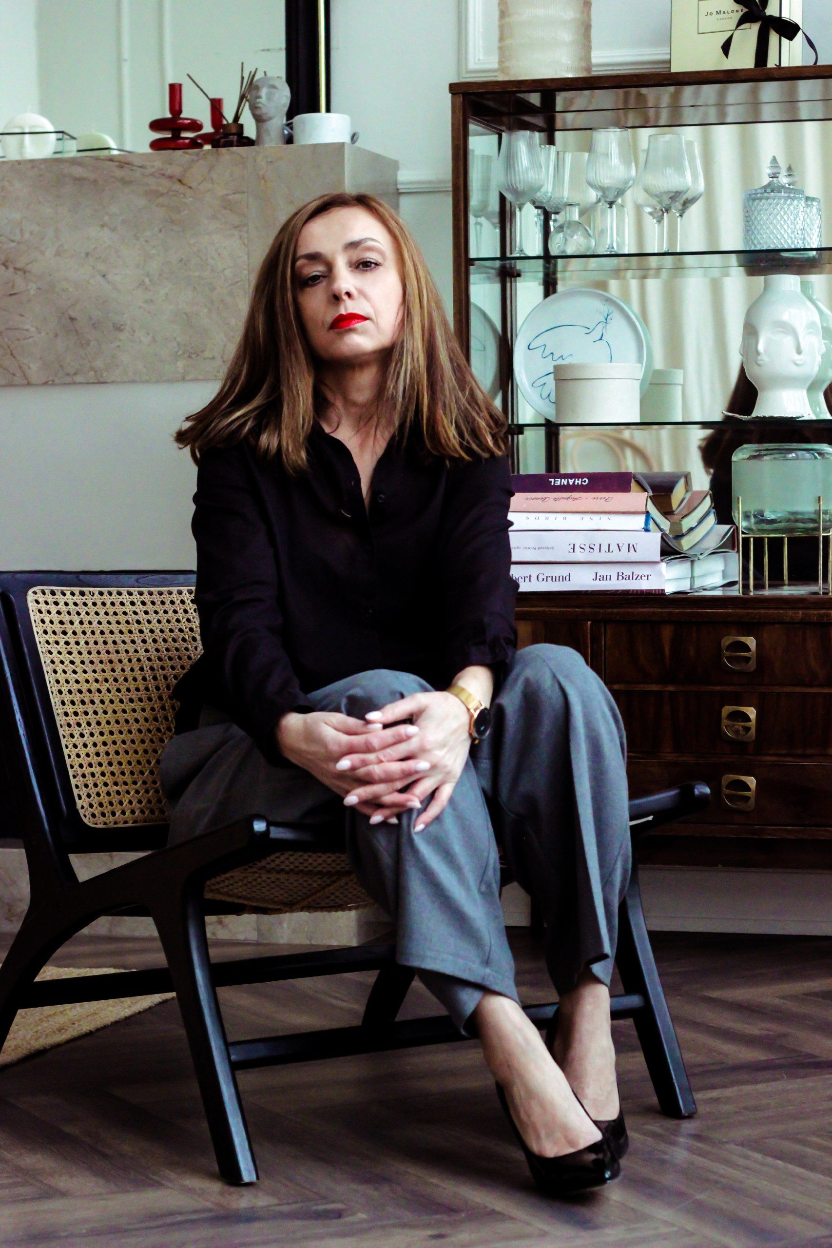 Confident woman seated in a stylish Minsk interior, exuding modern elegance.