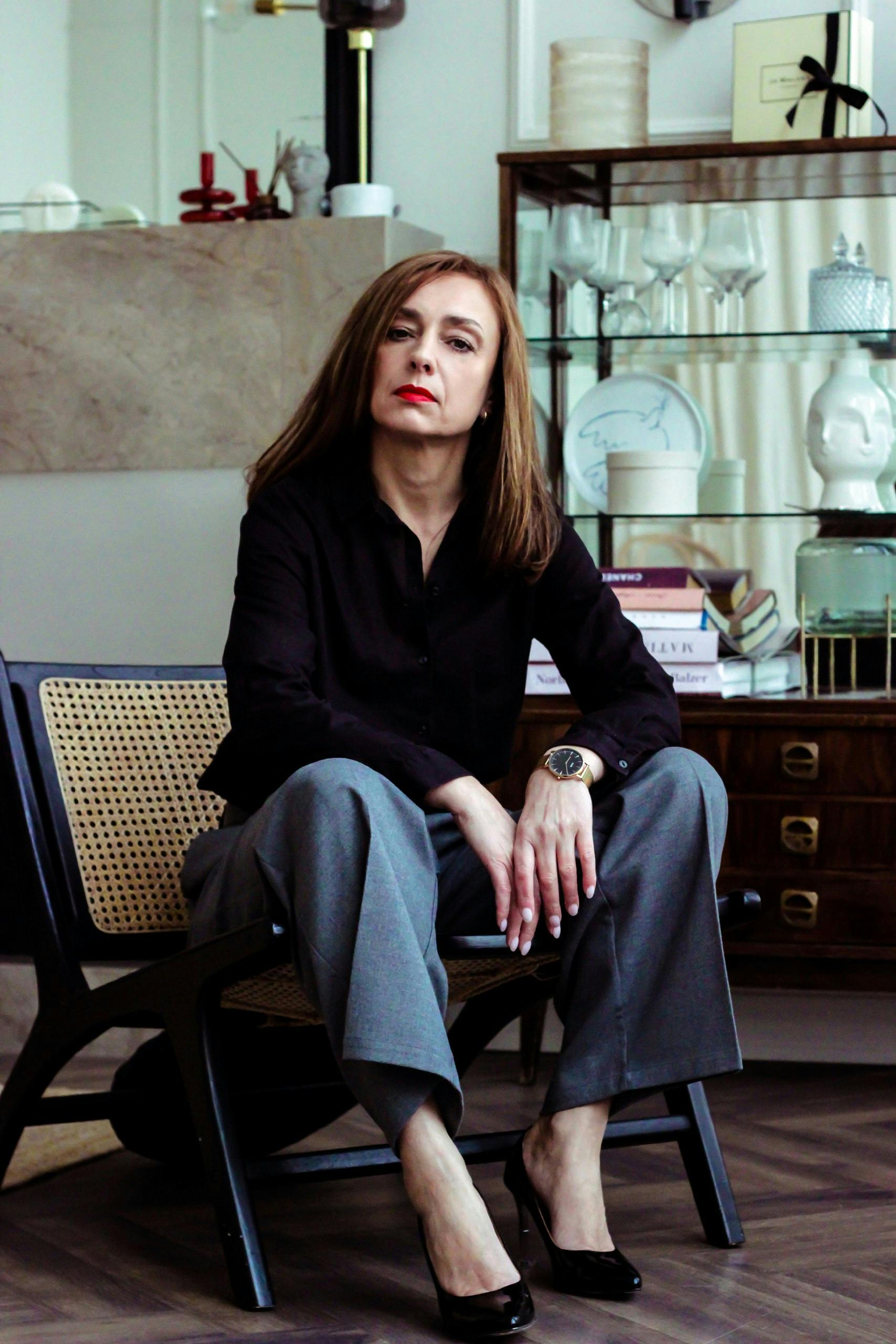 Professional woman sitting confidently in a stylish office environment, conveying authority and elegance.