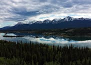 宁静的湖泊映衬着白雪皑皑的山脉，周围环绕着郁郁葱葱的森林