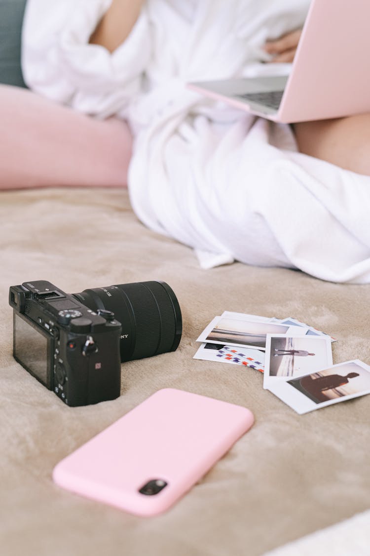 Black Camera And Cellphone On The Bed