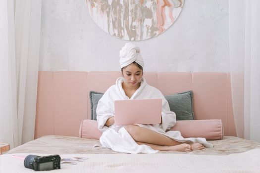 Woman in White Hijab Sitting on Bed Using Macbook