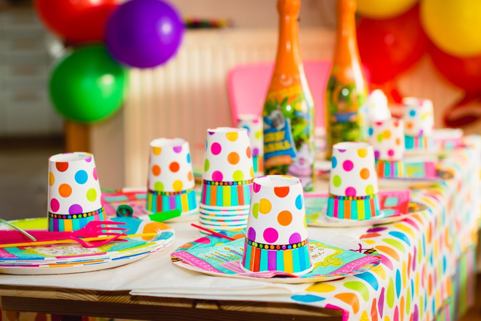 Colorful party table setup with polka dot cups and balloons, perfect for celebrations.