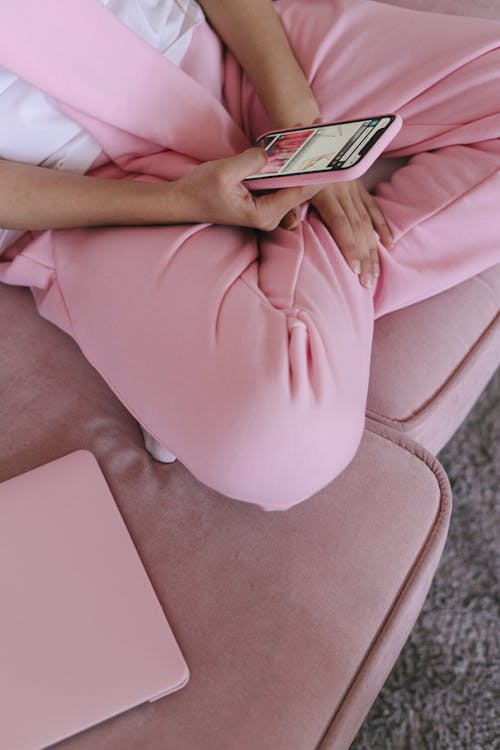 Woman in Pink Sweat Pants and Sitting on Couch