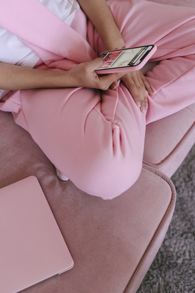 Woman In Pink Sweat Pants And Sitting On Couch