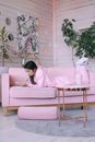 Woman in Pink Long Sleeve Shirt Sitting on White Couch