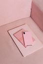 A Pink Smartphone and Notebook on Top of a Tablet