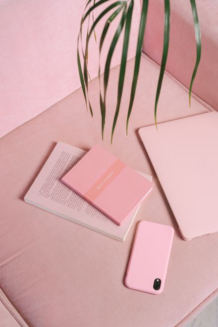 Pink flat lay with notebook, phone and palm leaf — photo by Ivan S on Pexels