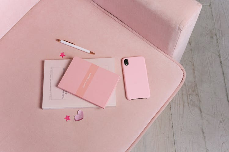 Books And A Smartphone On A Pink Couch