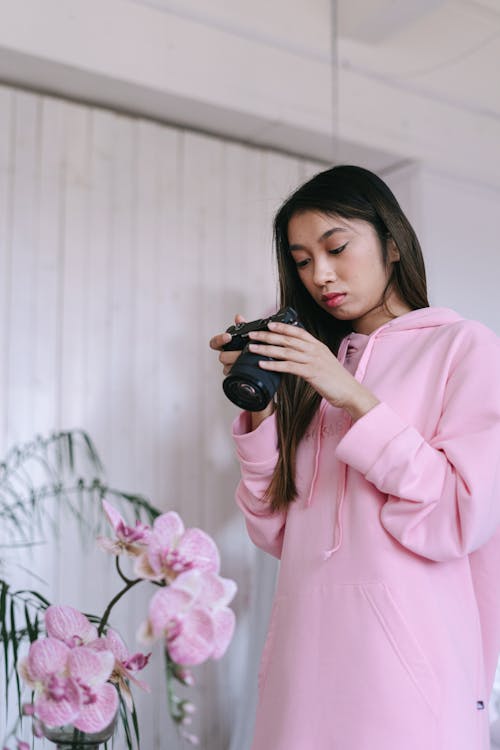 Woman in Pink Hoodie Holding Black Camera