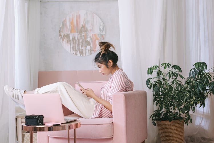 A Woman Relaxing On A Pink Sofa Chair