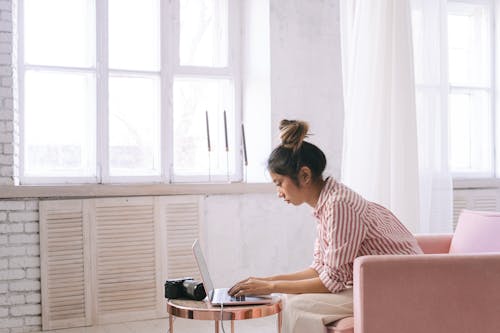 Free Woman in Striped Shirt Sitting on Chair  Stock Photo
