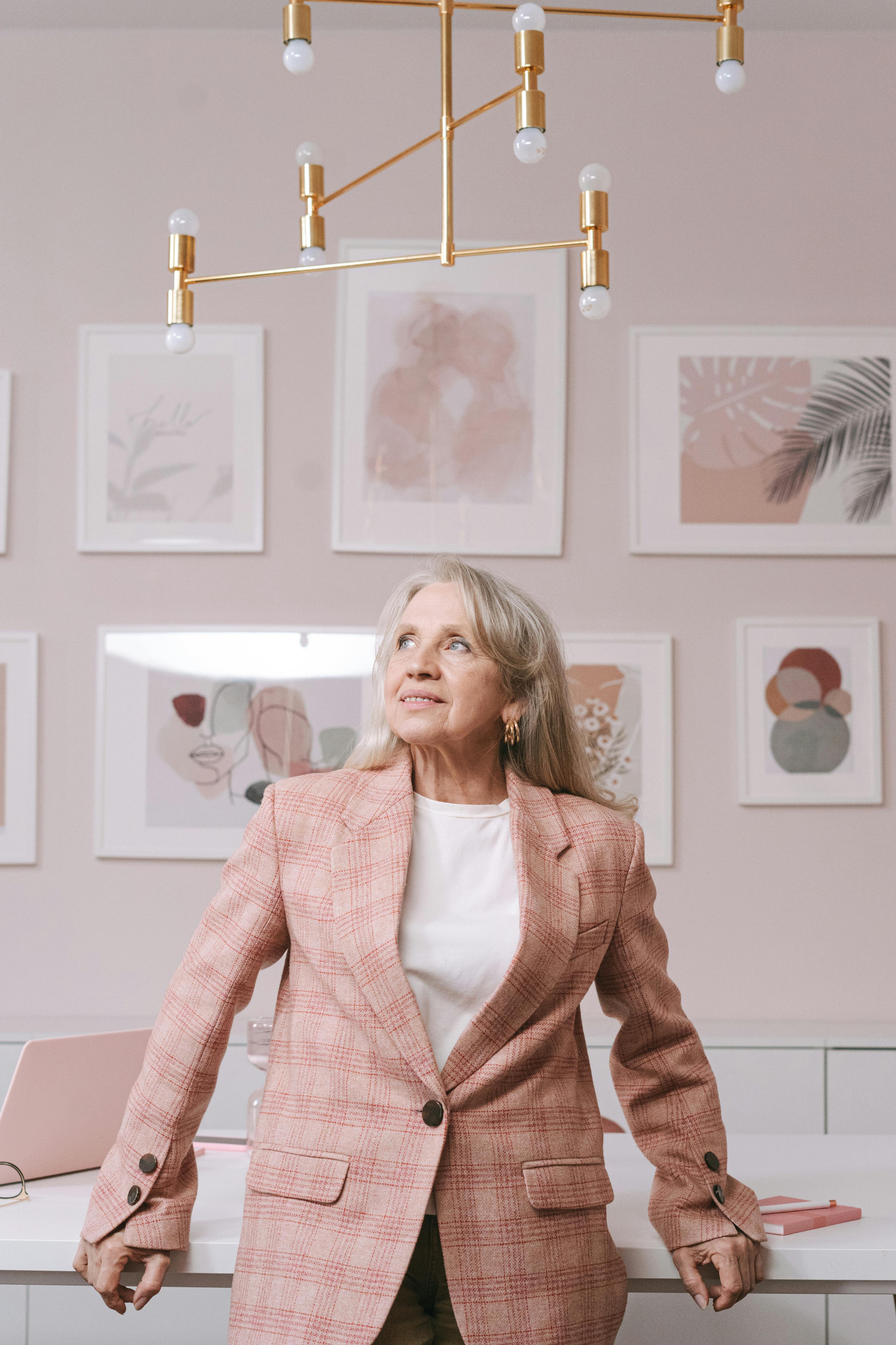 an elderly woman in pink blazer smiling while looking up