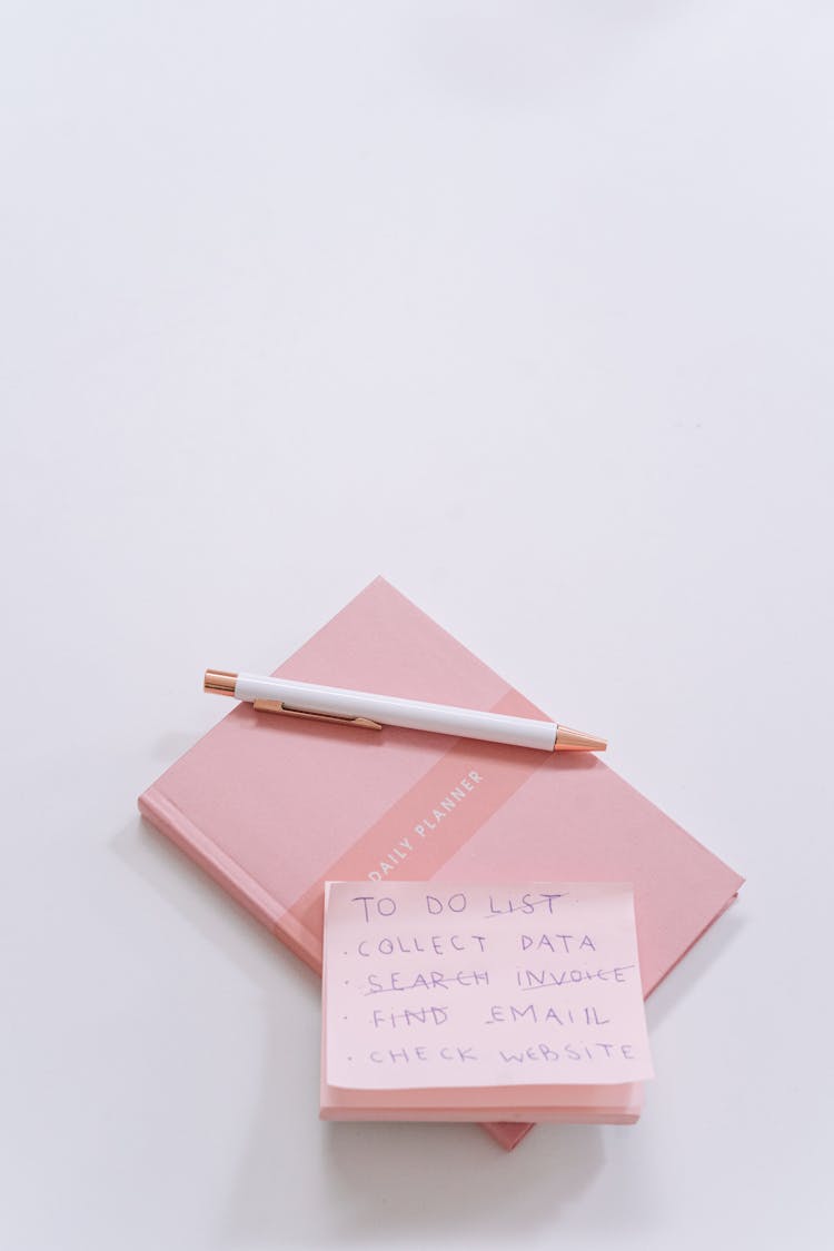 Pink Sticky Notes And Notepad On White Surface