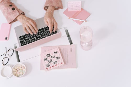 Free Person Using Pink Laptop on White Table Stock Photo