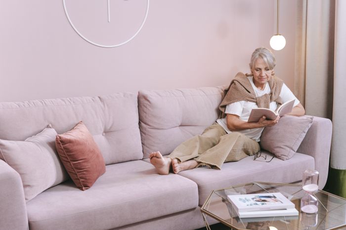 A woman reading on a sofa at home, photo by Ivan S on Pexels