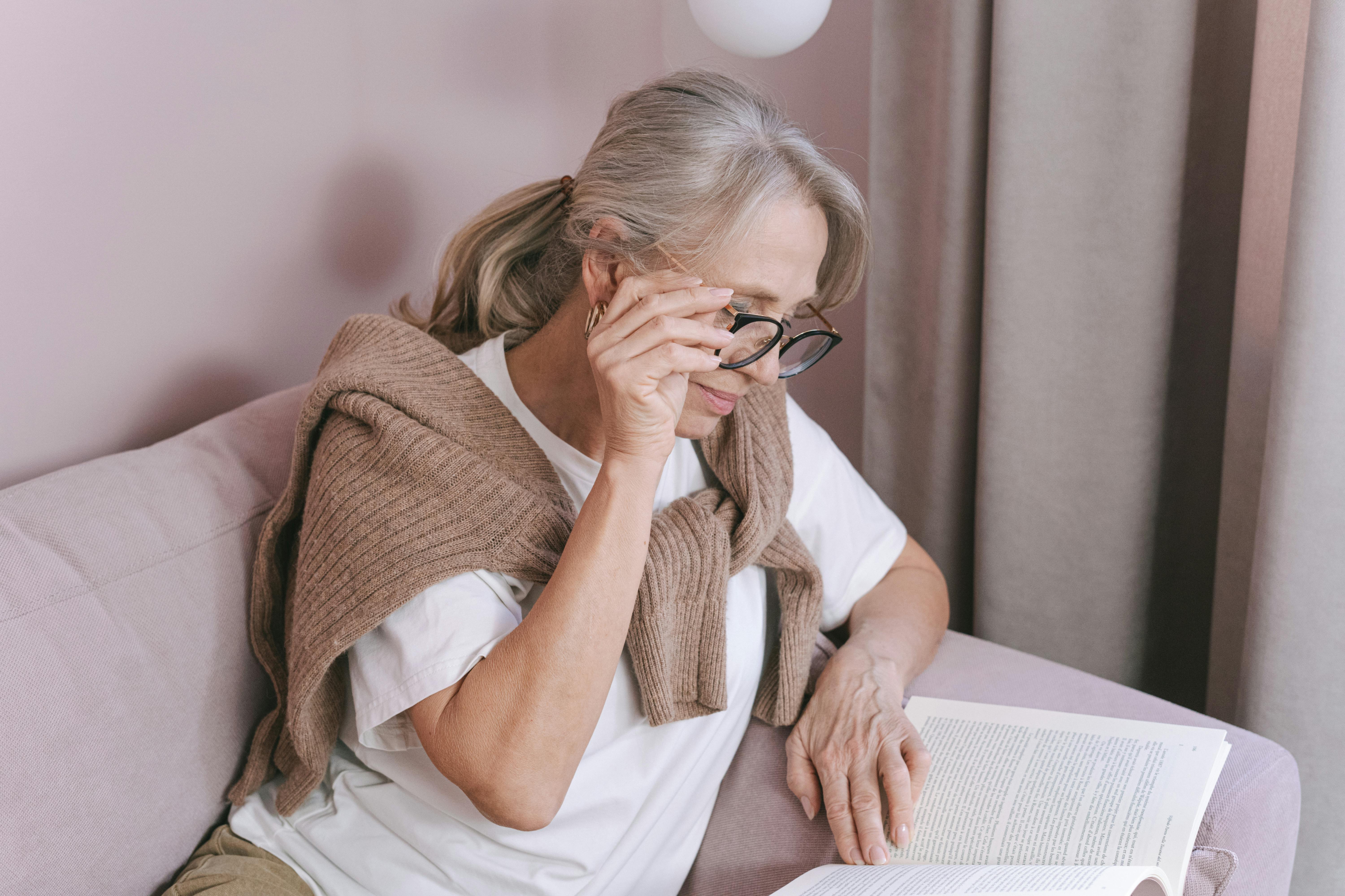 photo of an elderly woman with gray hair reading a book