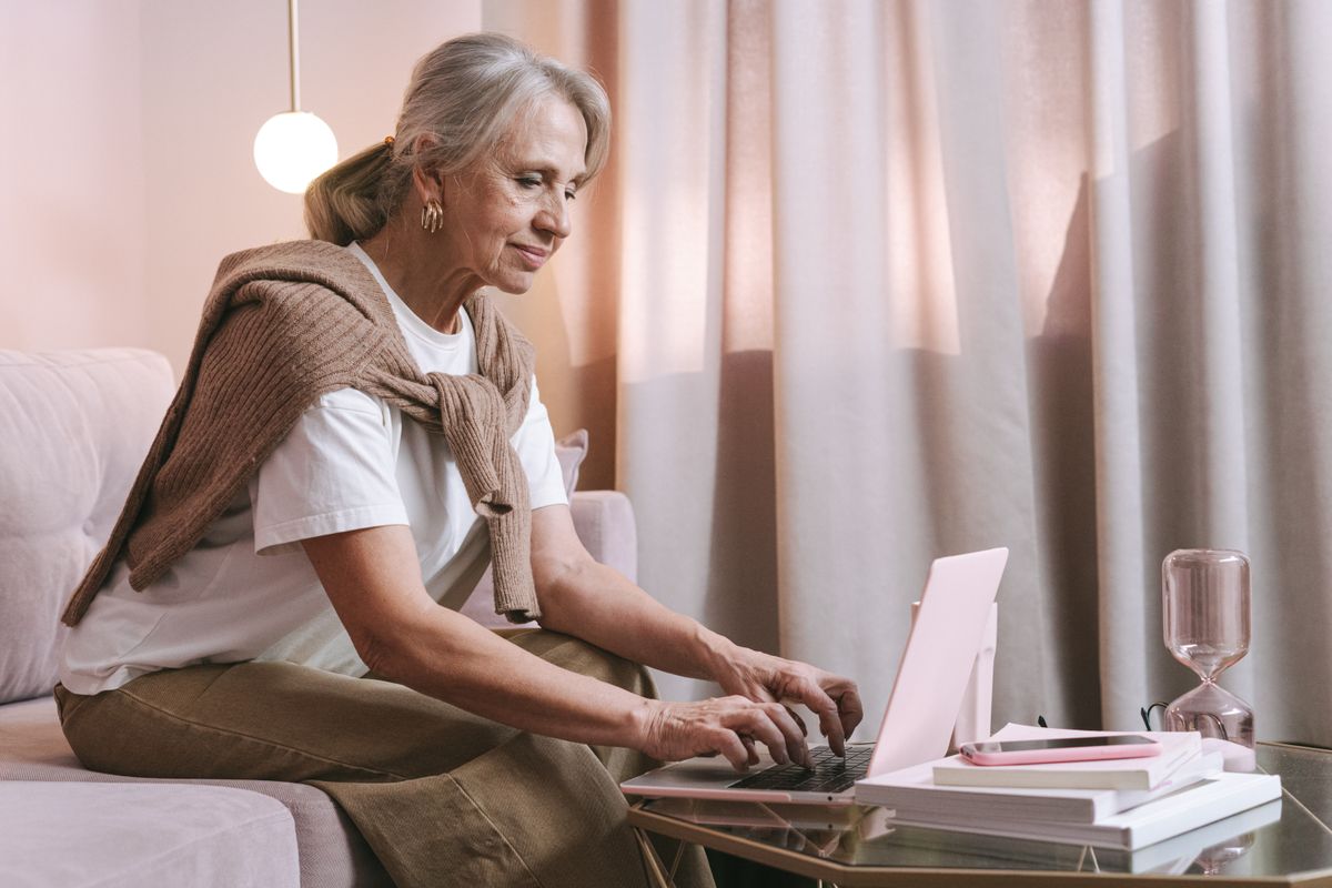 An older adult confidently using a laptop at home