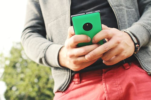 Person Holding Green Smartphone