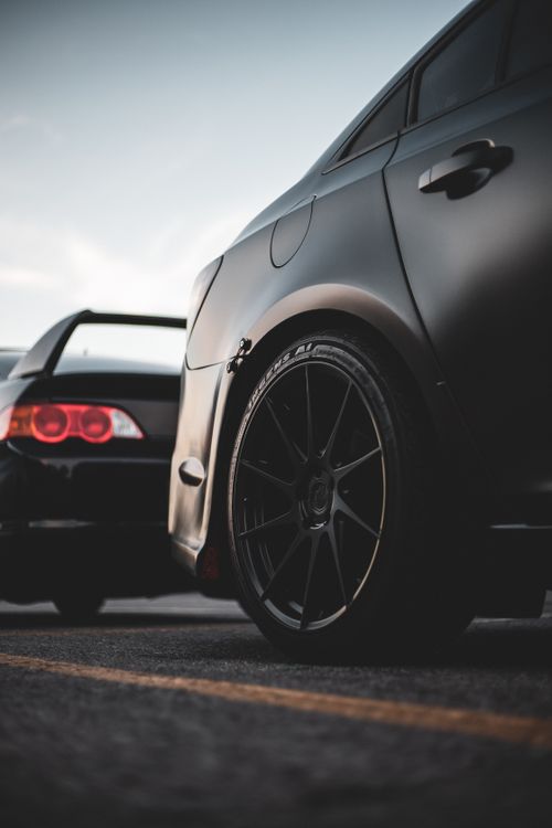 Free Sleek cars parked outdoors showcasing modern alloy rims and stylish design. Stock Photo