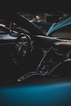 Stylish view of sleek car interior with focus on steering wheel and dashboard.