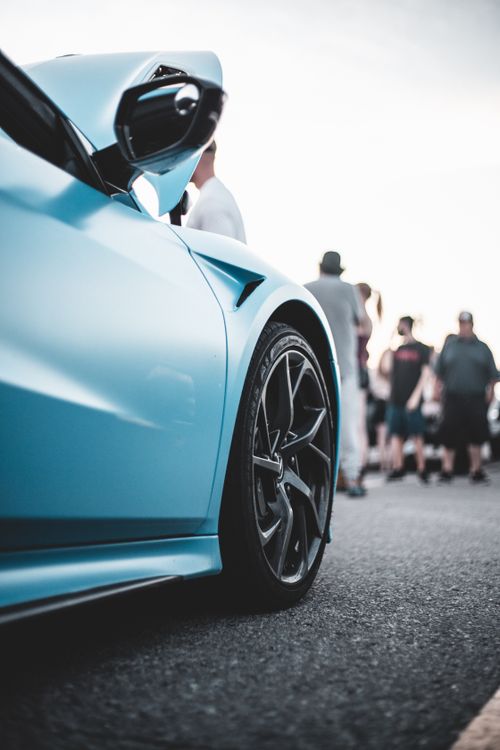 Free Dynamic shot of a luxury blue sports car with carbon fiber wheel details. Perfect for automotive enthusiasts. Stock Photo
