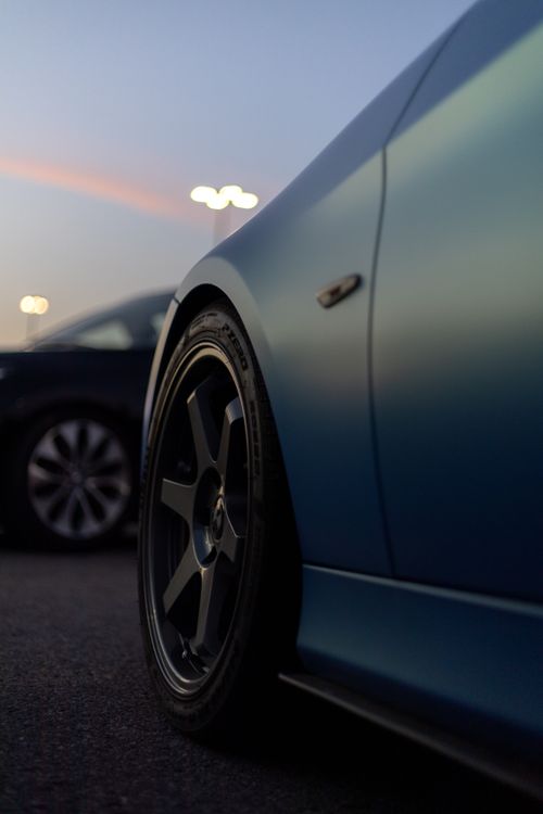 Free Close-up of a stylish car tire rim at dusk in an urban setting. Stock Photo