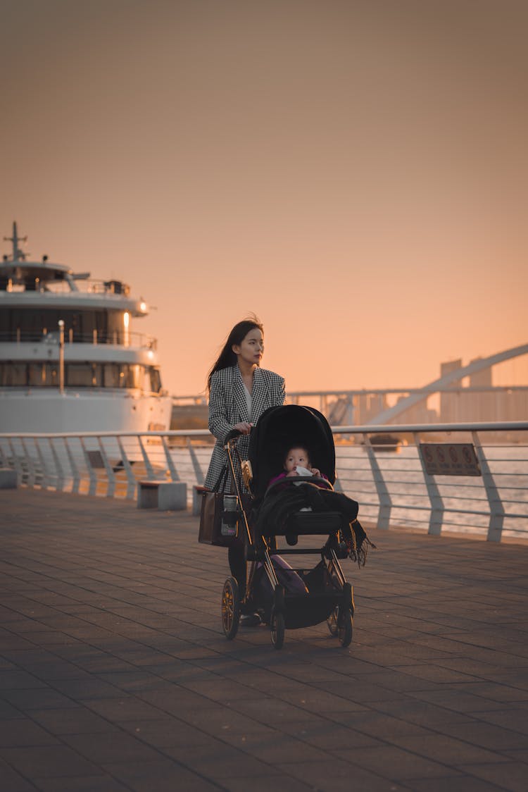 A Woman Pushing Her Baby In A Stroller