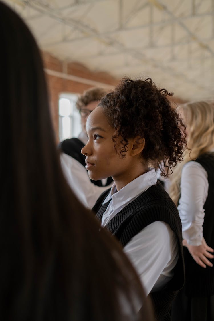 Side View Of A Girl With Curly Hair Wearing A School Uniform