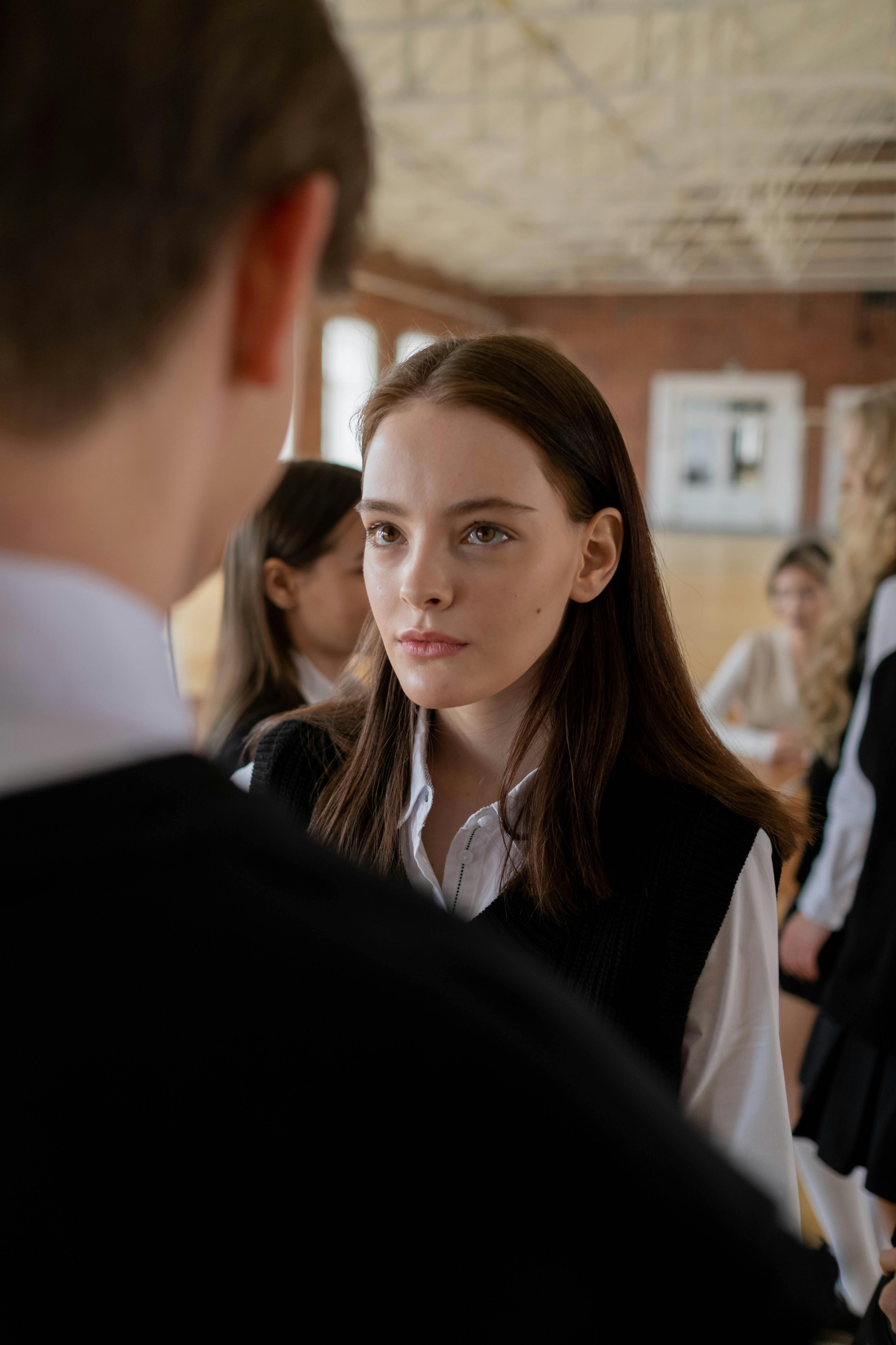 girl in a uniform looking at her classmate