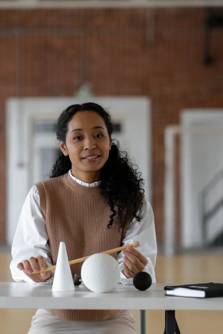 A Woman In White And Brown Long Sleeve Shirt Holding A Stick