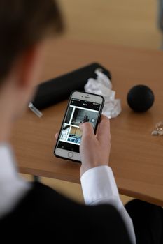 Adult using a smartphone at a desk with office items, showcasing a casual work setting.