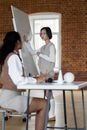 Woman in White Blazer Sitting on Chair Using Laptop Computer