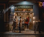Women Wearing Face Masks Standing Outside a Store at Night