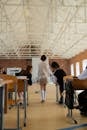 Woman in White Dress Shirt and White Skirt Standing on White Floor Tiles