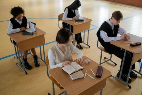 Free Group of diverse students studying in a well-lit indoor classroom setting. Stock Photo