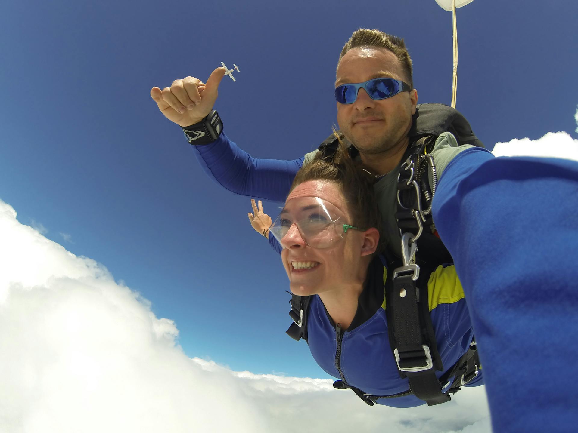 Tandem skydivers enjoying an exhilarating freefall through clear blue skies.