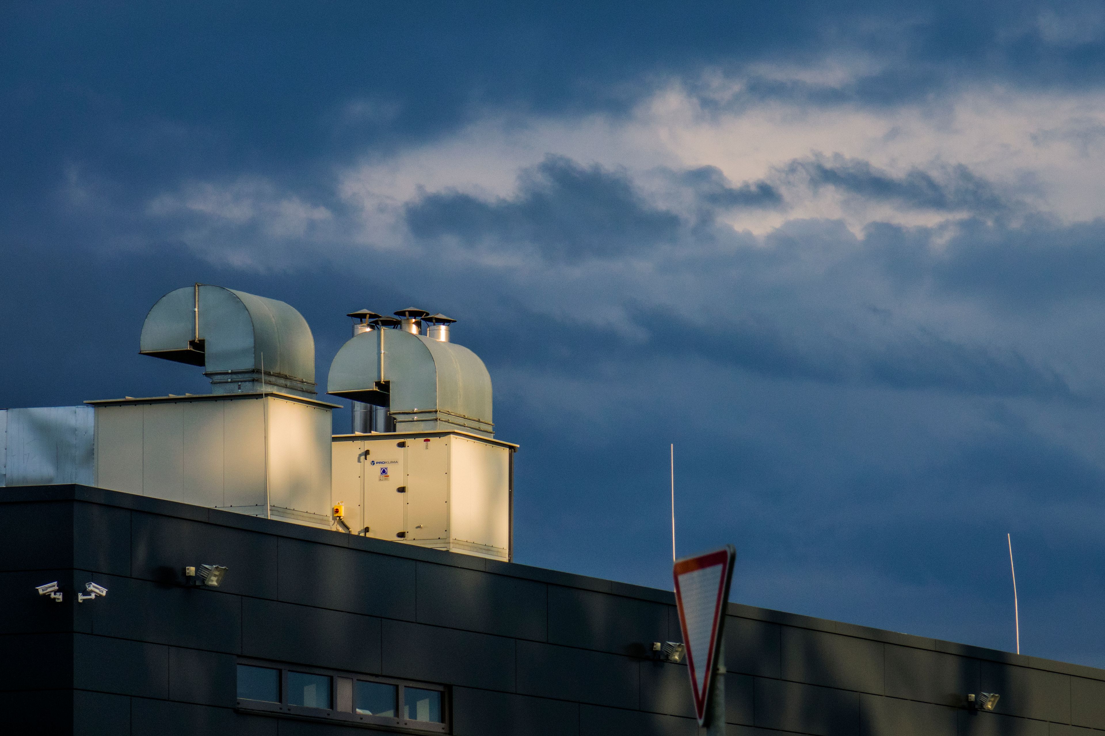 Réseau d'extraction en toiture Vue en contre-plongée du réseau de gaines d'extraction installé sur la toiture d'un bâtiment