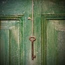 Old key hanging on wooden door
