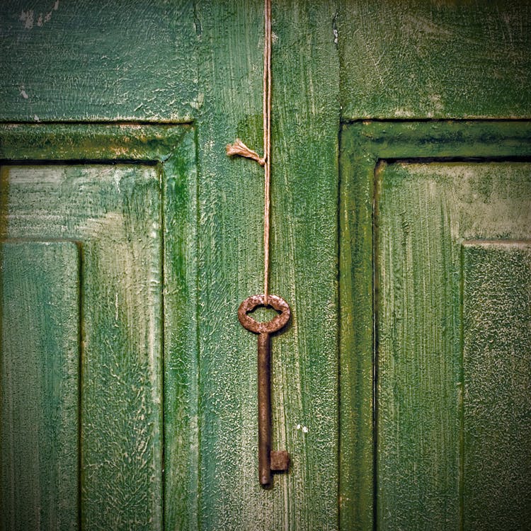 Old Key Hanging On Wooden Door