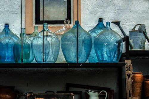 Free Empty glass bottles placed on shelf in shabby pantry in rustic house in countryside Stock Photo