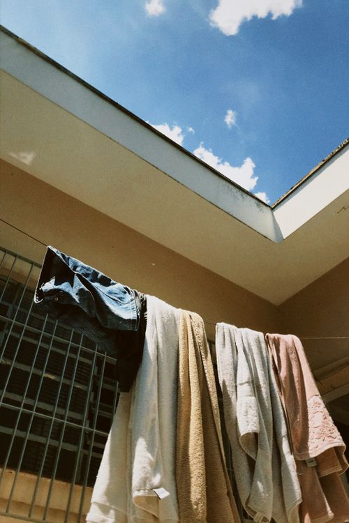 Free A low angle view of laundry drying on a clothesline with a bright blue sky in the background. Stock Photo