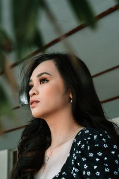 Profile portrait of a woman with long hair and floral dress, captured with soft natural lighting.