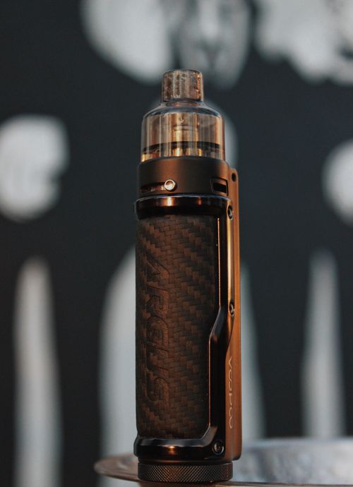 Free Stylish vape pen with carbon fiber pattern against blurred abstract background. Stock Photo