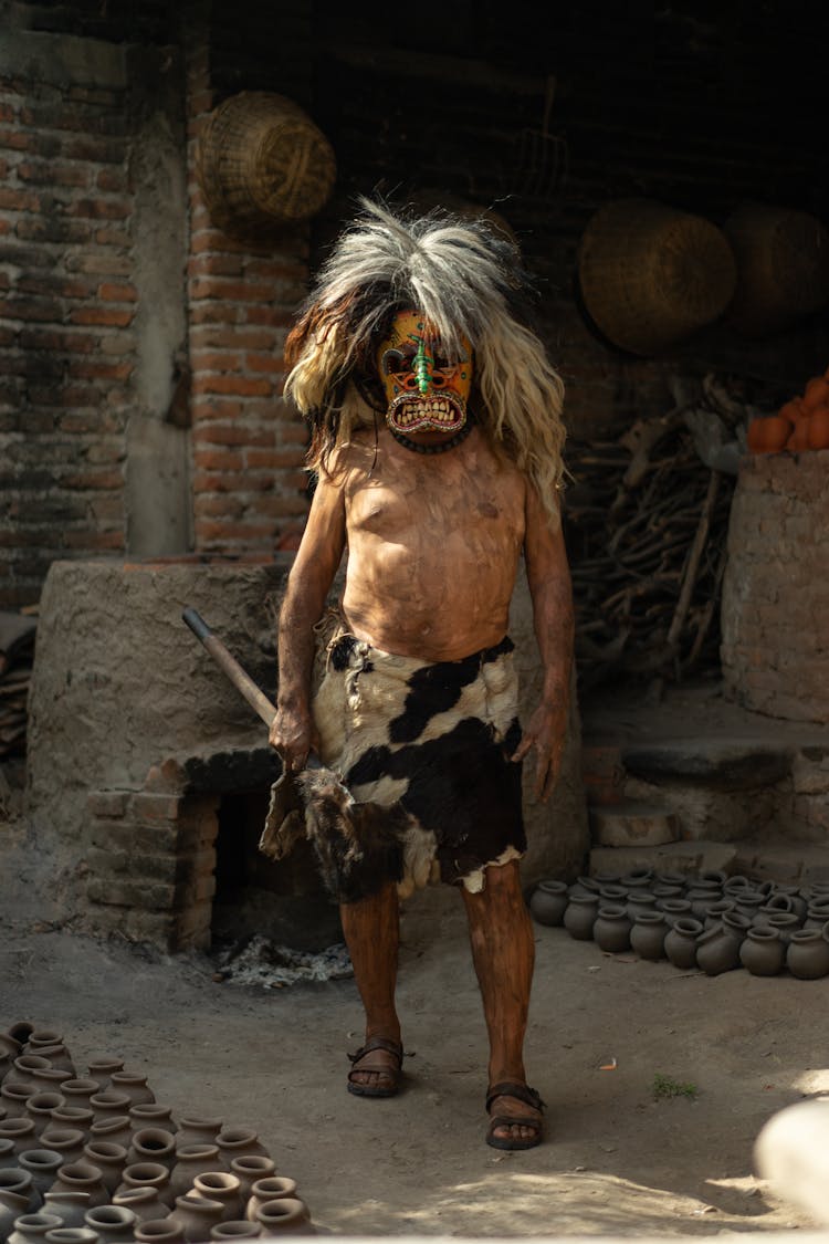 Shirtless Man Wearing A Scary Mask And Animal Skin