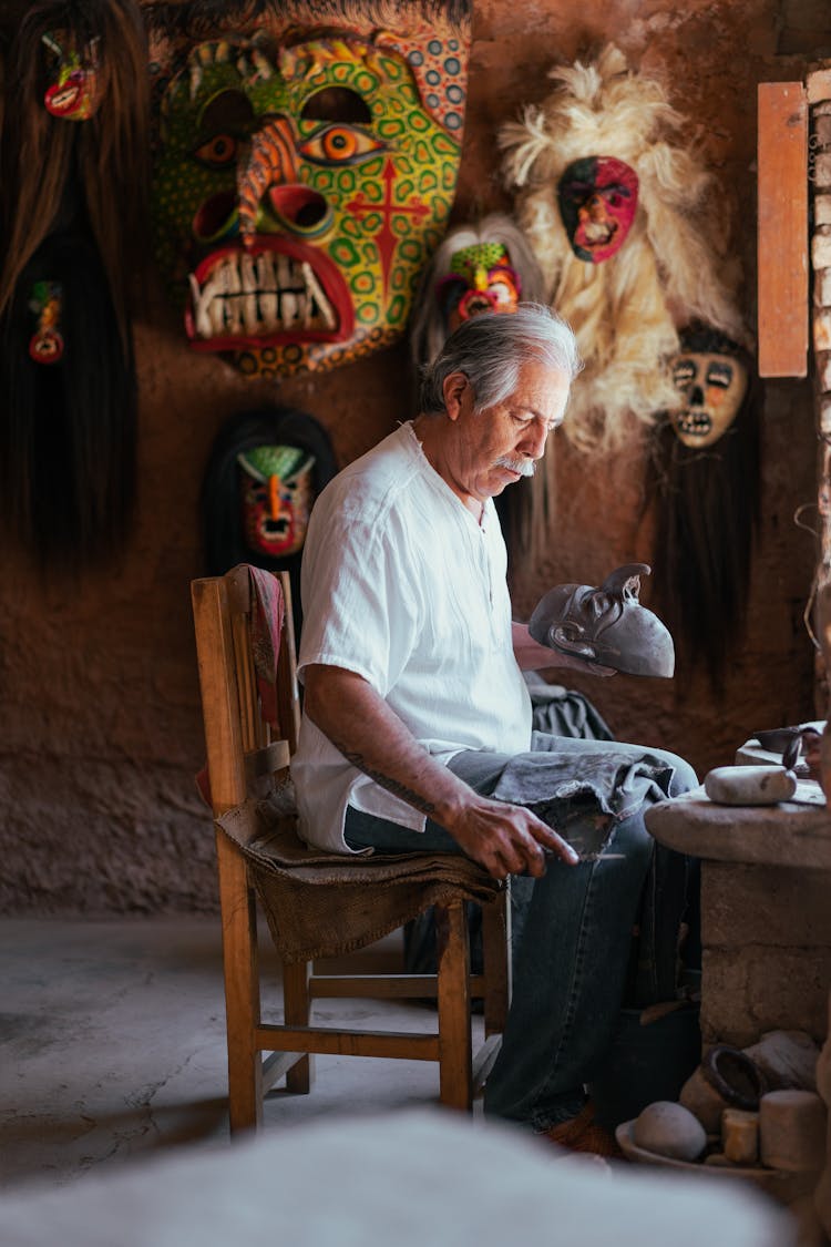  A Man Making Masks Using Clay