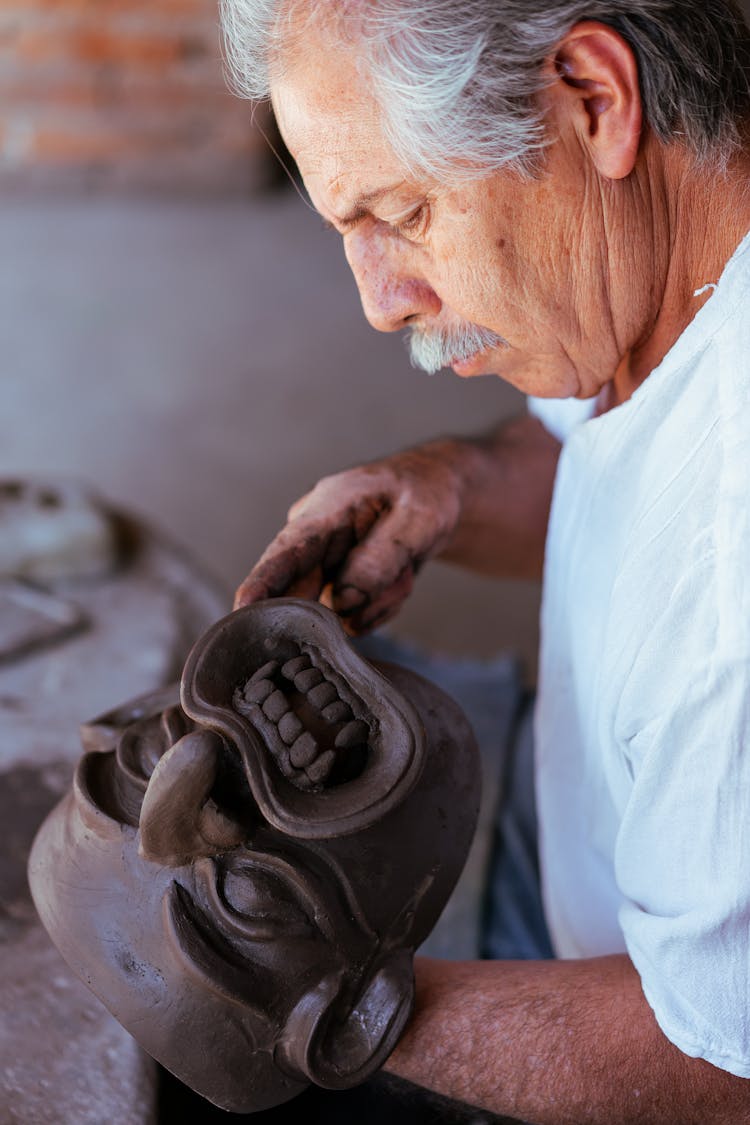 An Elderly Man Making A Mask