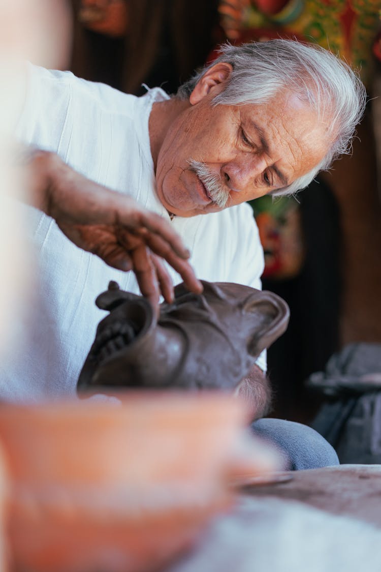 A Man Molding A Clay Mask