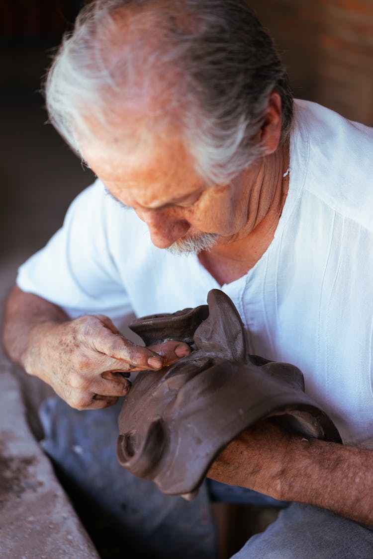An Elderly Man Making A Clay Mask