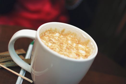 Warm cappuccino with frothy top in a white mug, perfect for cozy moments.
